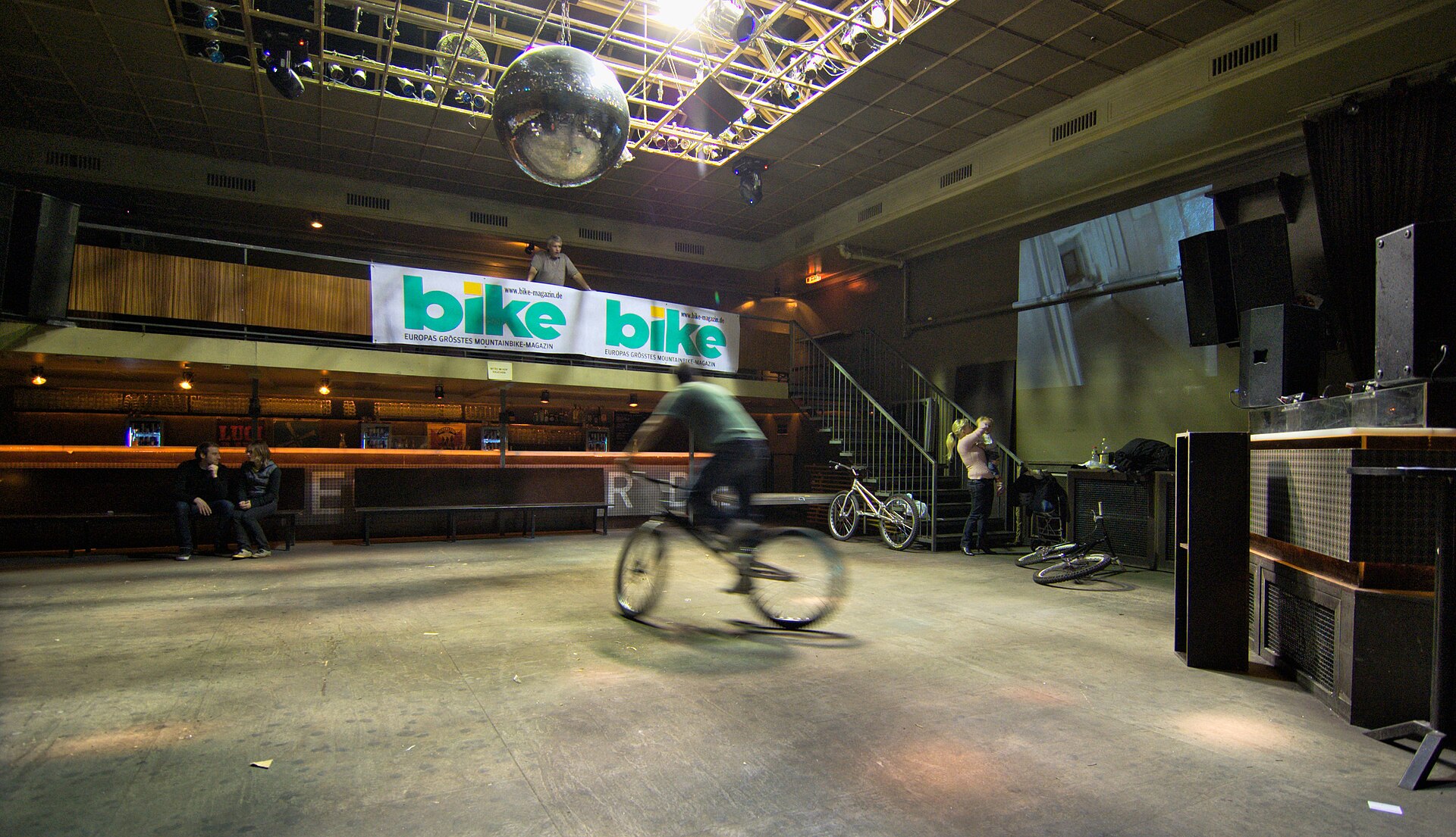Inimesed tantsivad rahvarohkel ööklubi tantsupõrandal neonvalgustuses.